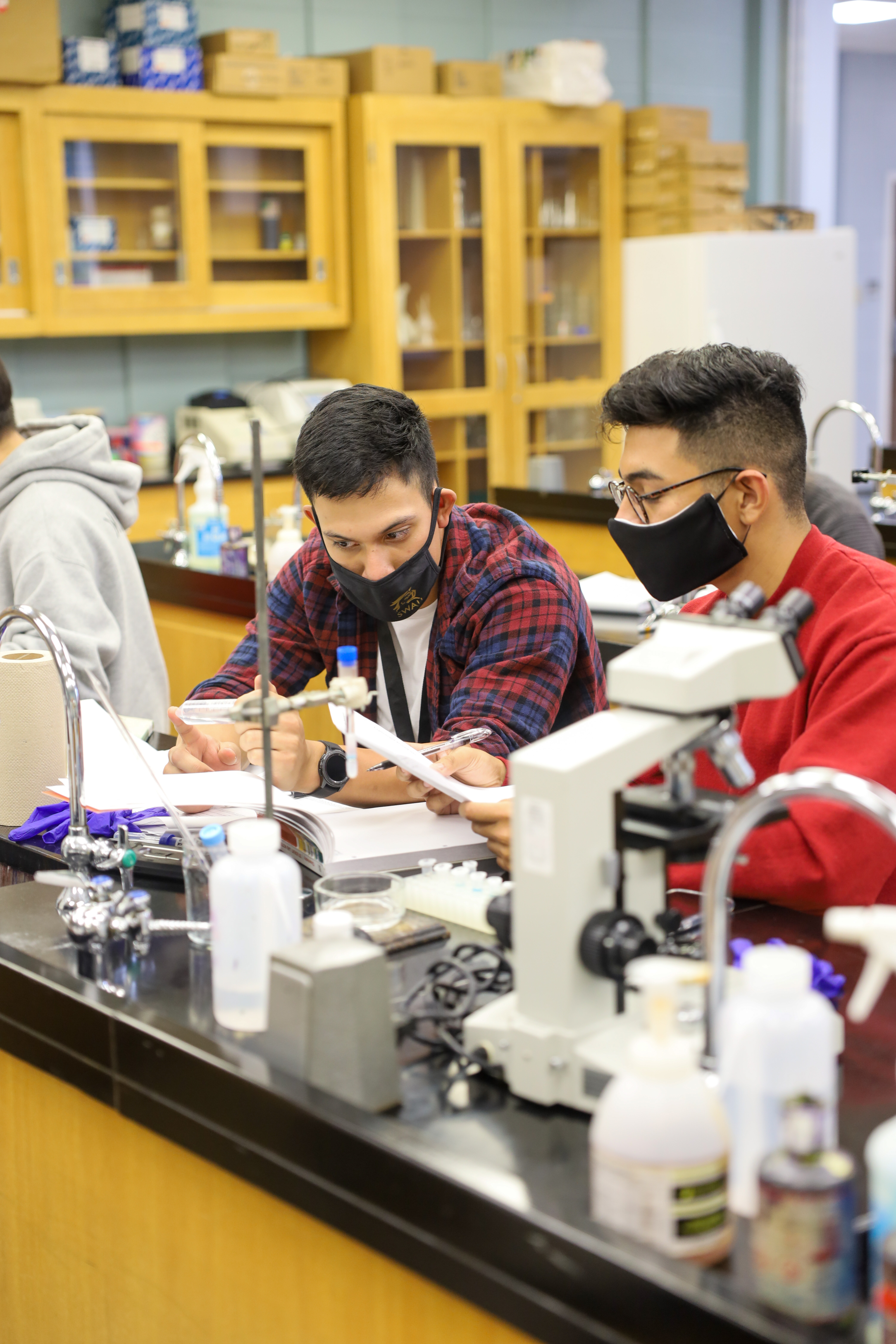 Male students in a lab looking at a solution 