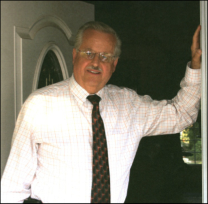 Dr. Karl Konrad stand in the doorway of a home with his hand on the doorframe 