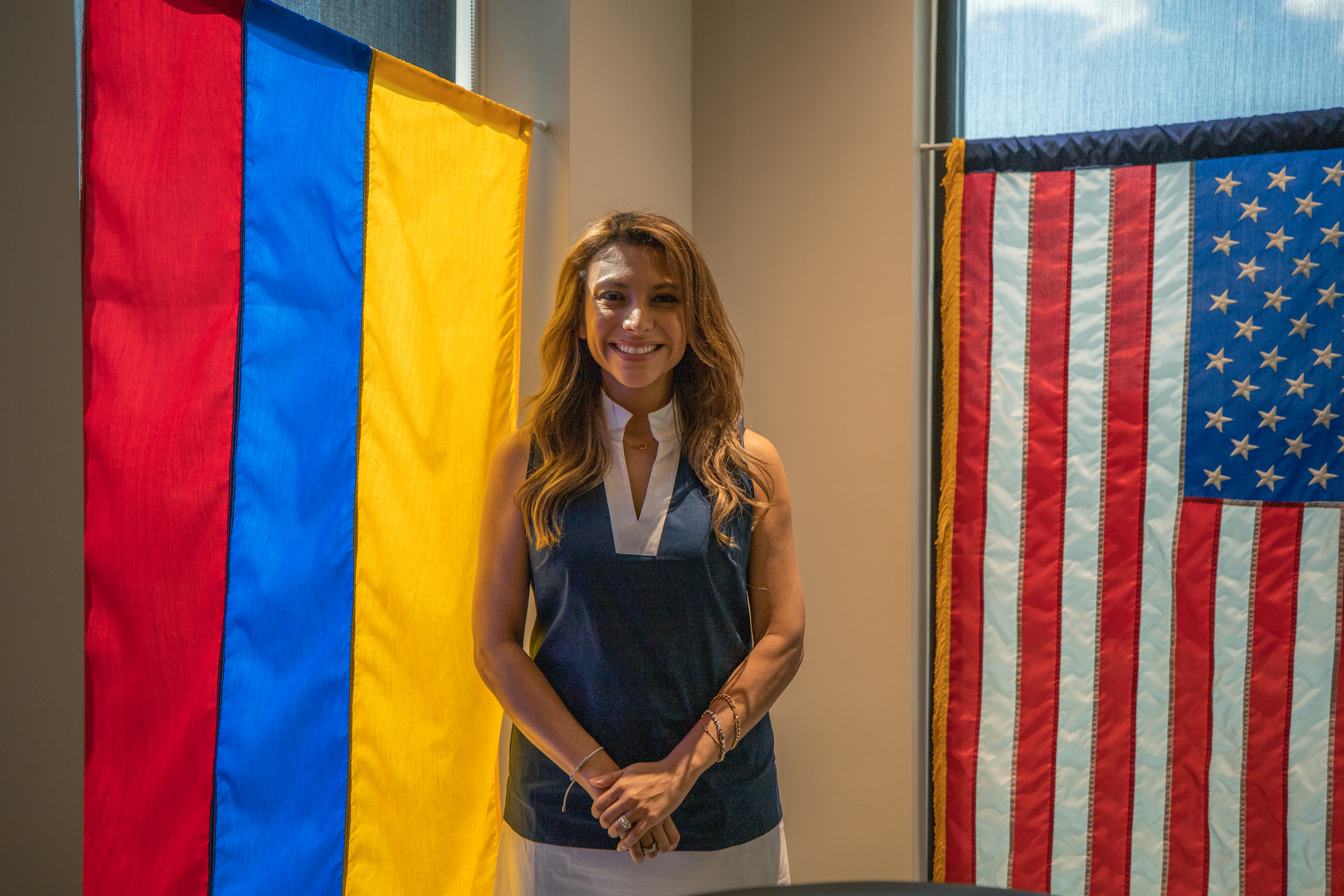 Liliana poses in front of the Columbian and American flags