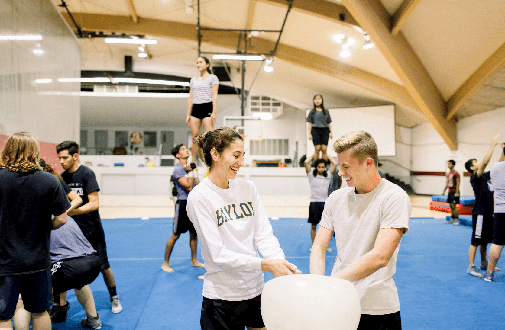 In the gymnasium, the SWAT team practices in the background while we focus on two of the members applying chalk on their hands preparing to practice