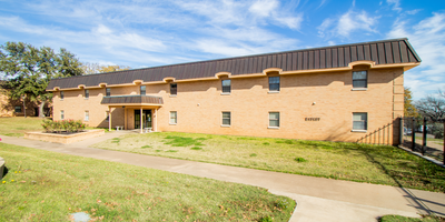 The exterior of Hadley, which is a long building with a light brick and a brown roofing