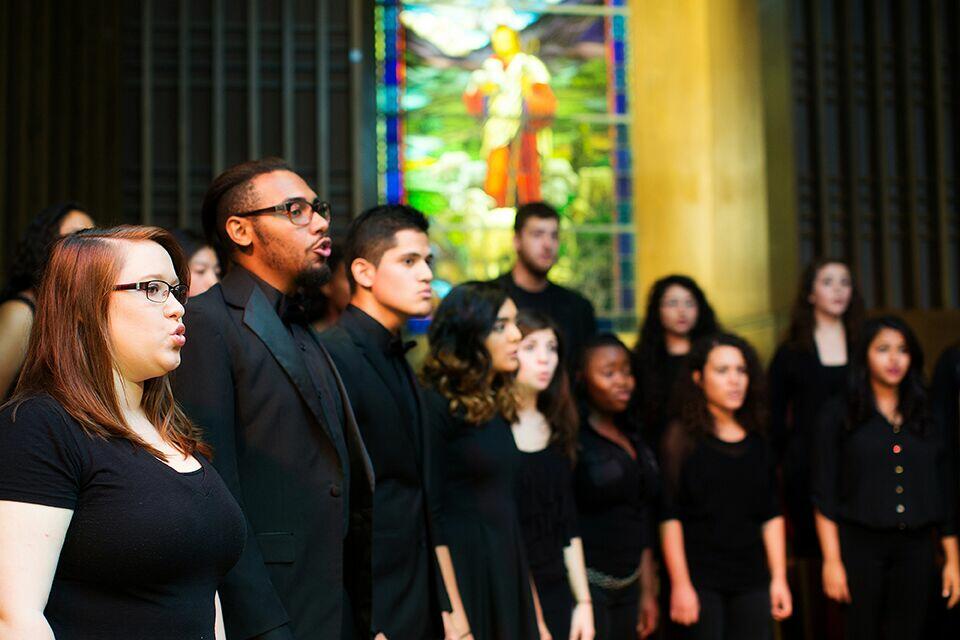 A group of college students wear all black as they sing at the church