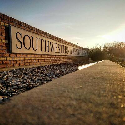 Outside sits a short, but long brick sign that reads " Southwestern Adventist University"