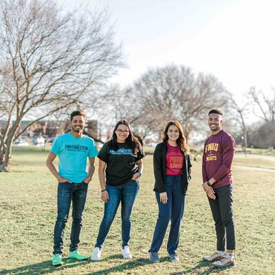 Four students of different ethnicities standing next to each other and smiling