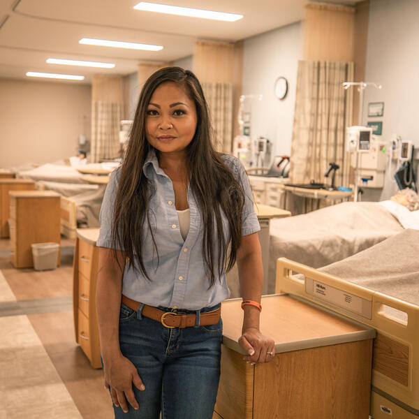 Karen Phongsavan posing in the Southwestern Adventist University nursing lab in jeans and a denim button up