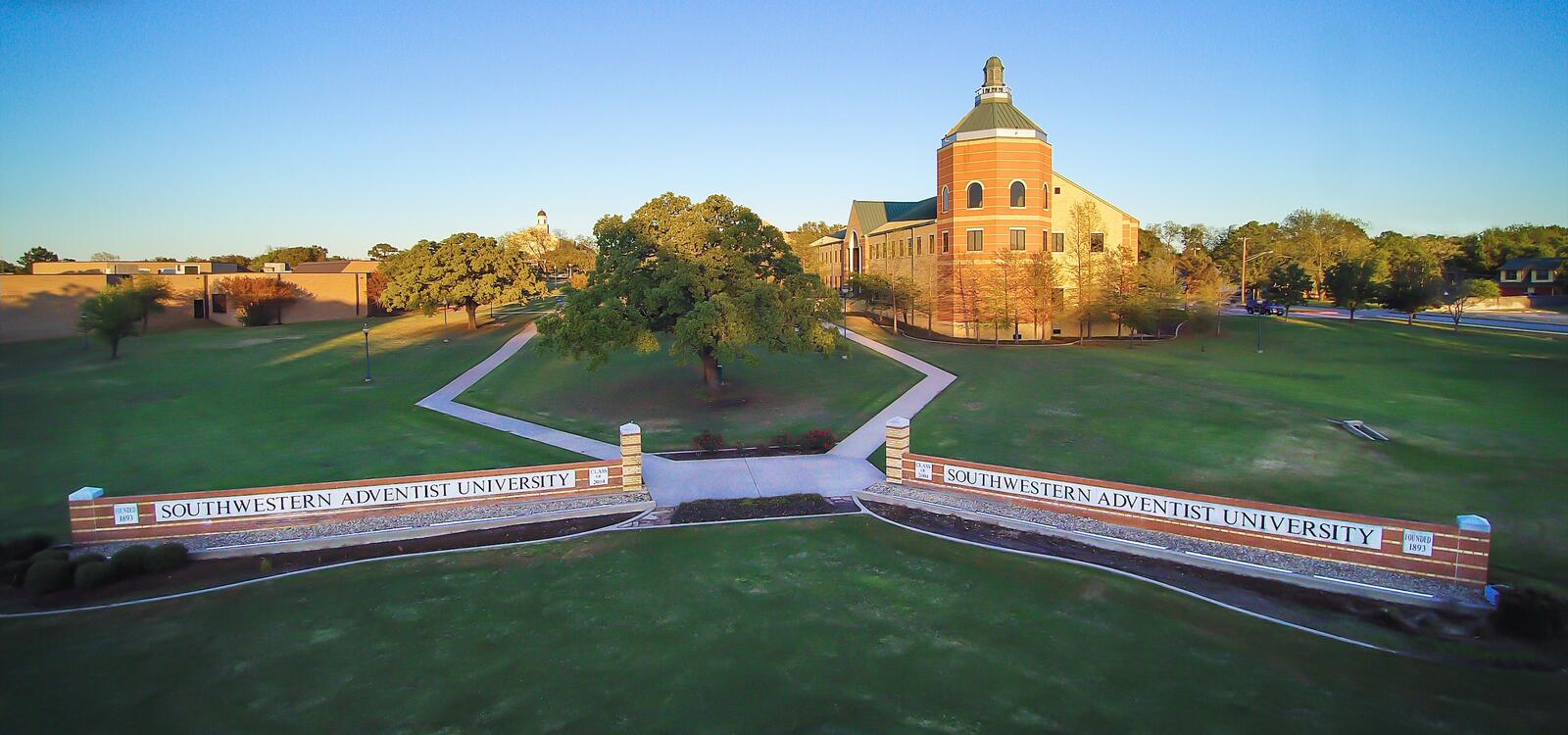 Birdseye view of the university, showcasing the Pechero building and two matching brick signs that read " Southwestern Adventist University"