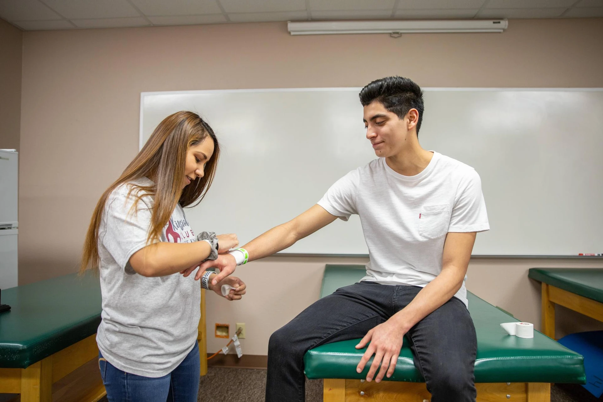 Two students practicing wrapping an injury at the kinesiology building.