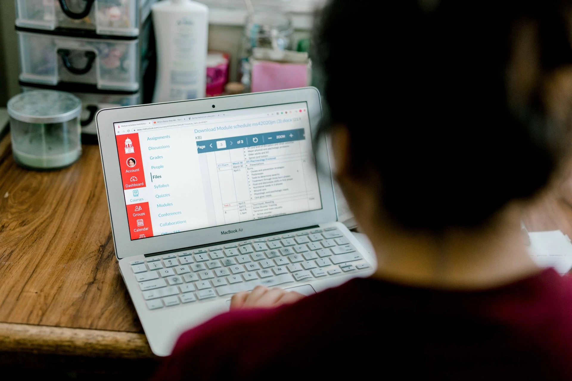 A student opens her laptop and goes to SWAU's academic portal known as Canvas